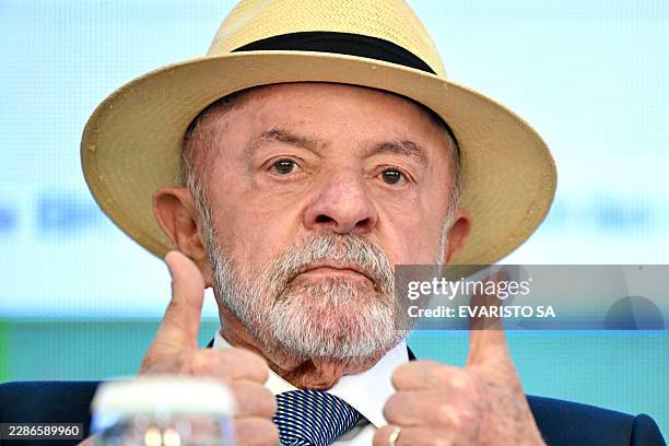 Brazil's President Luiz Inacio Lula da Silva gives the thumbs up during the signing of the law establishing a line of credit for companies affected...