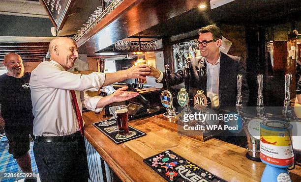 Prime Minister Andy Burnham drinks a pint of beer as he visits the Hare Inn in Harlow, Essex with the Chancellor John Healy on July 23, 2026 in...