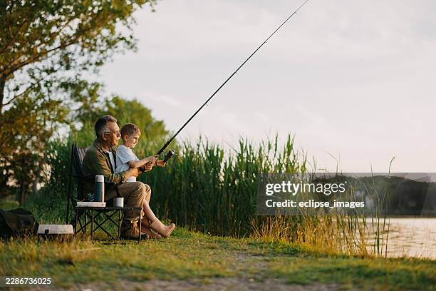 grandfather teaches grandson to fish - fishing tackle stock pictures, royalty-free photos & images