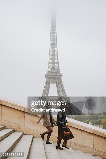 Zwei Freunde genießen ihre Reise nach Paris mit dem Eiffelturm im Hintergrund Zwei Freunde genießen ihre Reise nach Paris mit dem Eiffelturm im Hintergrund