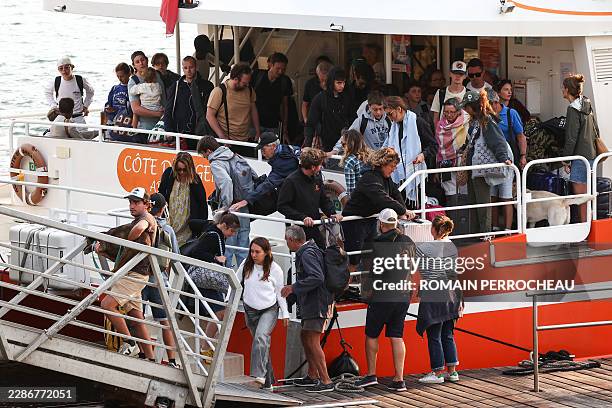 Holidaymakers from Lege-Cap-Ferret disembark from a boat upon their arrival in Arcachon during an evacuation operation of the entire Cap-Ferret...