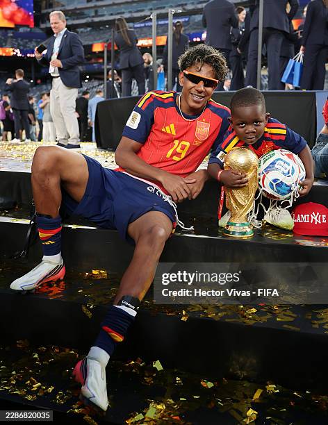 Lamine Yamal of Spain celebrates with his little brother Keyne and the FIFA World Cup Winner's Trophy after the team's victory following the FIFA...