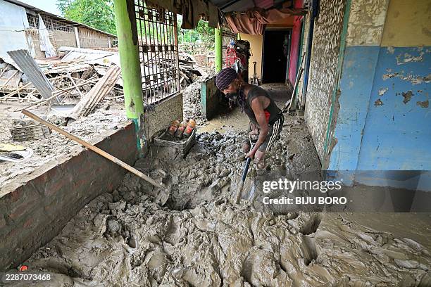Man clears sludge from his house following flash floods triggered by heavy rain in Assam's Sivasagar district on July 26, 2026.
