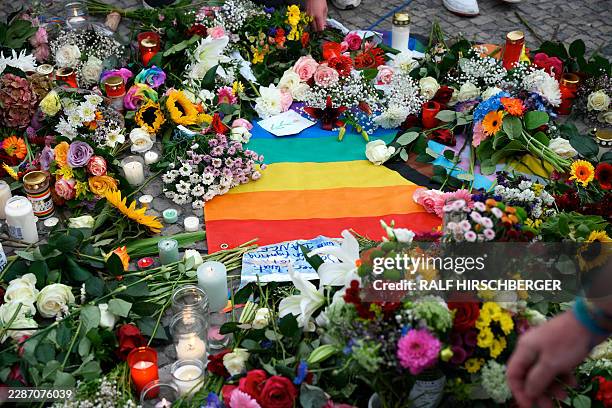 Many flowers, candles and a rainbow flag are displayed on July 26, 2026 on Pariser Platz in front of landmark Brandenburg Gate during a so-called...