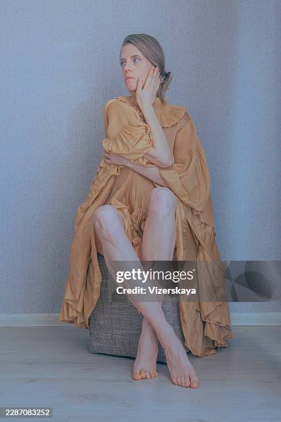 portrait of a young blonde woman sitting in a corner - levitation bildbanksfoton och bilder