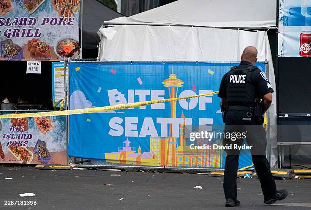 Police officer walks by a sign for the Bite of Seattle food festival on July 26, 2026 in Seattle, Washington. Two people are dead and multiple people...