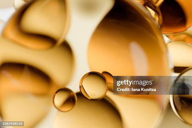 abstract 3d golden, yellow liquid oil drops, bubble, molecules. concept of omega-3, fish oil, cooking oil, collagen, vitamin supplements, skincare, face serum, biotechnology, biology. cosmetic product with peptides, folic acid, ceramides, hyaluronic acid. - massageöl stock-fotos und bilder