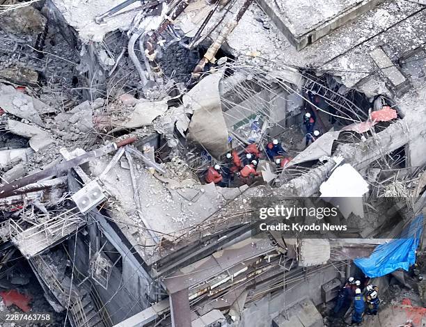 Photo taken from a Kyodo News helicopter shows search and rescue operations under way at a Nippon Paper Industries Co. Plant with its smokestack...