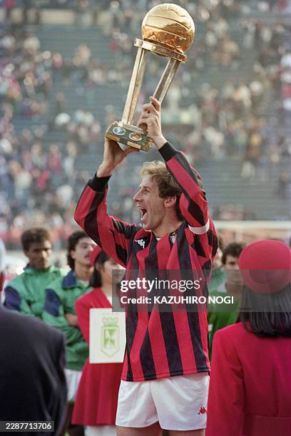Milan captain and defender Franco Baresi celebrates as he holds the trophy aloft after his team beat Nacional Medellin 1-0 in extra time in the...