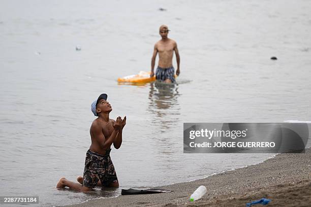 Migrant gestures on the beach around the border barrier with Morocco to enter Spain's north Africa's Ceuta enclave on July 31, 2026. Thousands of...