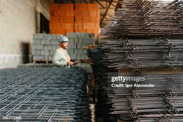 warehouse worker inspecting reinforcement mesh stock - construction material stock pictures, royalty-free photos & images