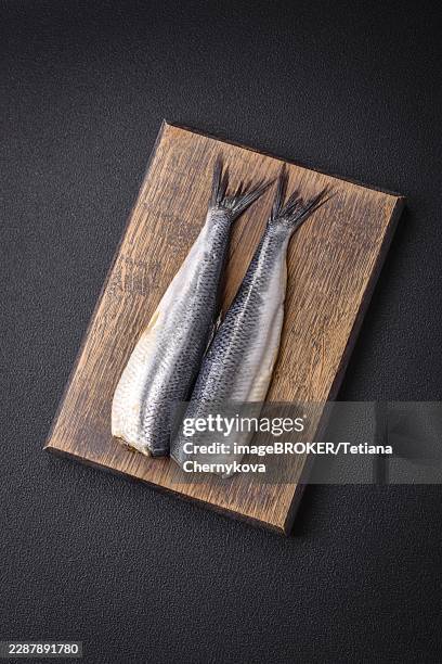 food, pacific herring fillet marinated with salt, spices and herbs on a dark concrete background - pacific herring stock pictures, royalty-free photos & images