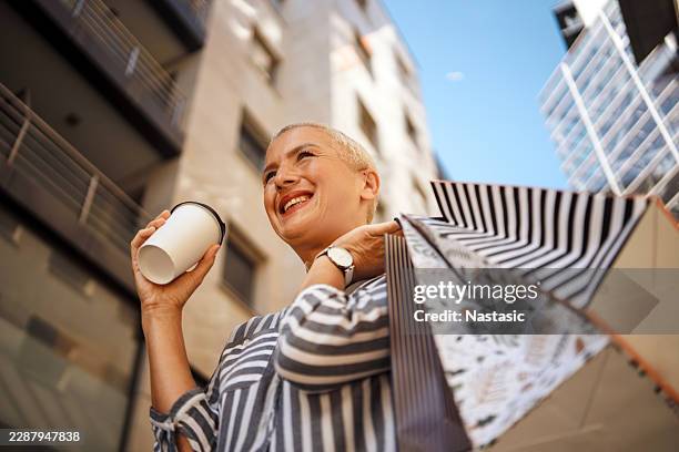 woman shopping in an urban environment - shopaholic stock pictures, royalty-free photos & images