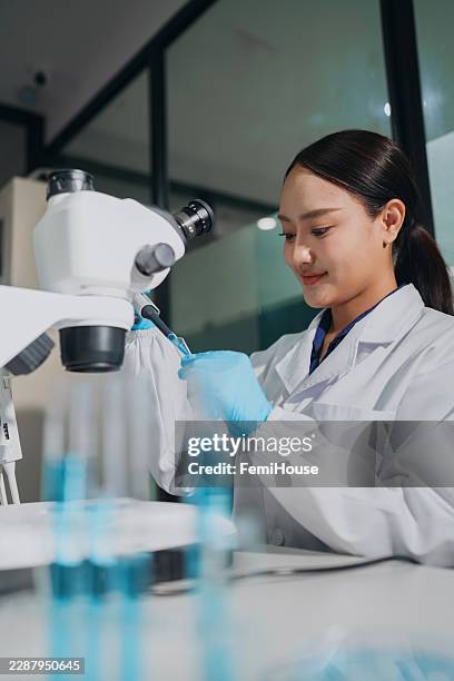 female scientist using micropipette for sample preparation in modern biotechnology laboratory - diagnostic medical tool stock pictures, royalty-free photos & images
