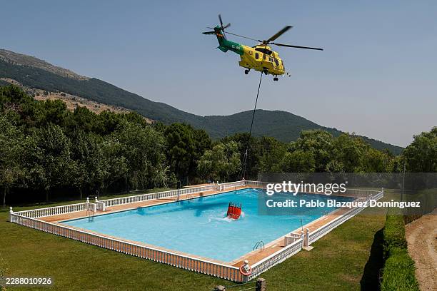 Helicopter collects water from a swimming pool to combat wildfires on July 28, 2026 in Casillas, in Ávila province, Spain. The wildfires that have...