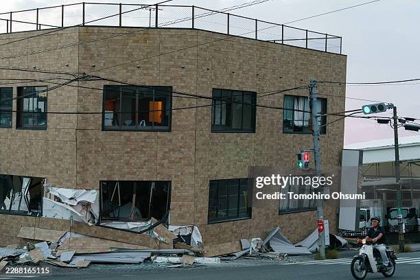 Man rides a scooter past a collapsed building on July 29, 2026 in Yatsushiro, Kumamoto Prefecture, Japan. A magnitude 7.1 earthquake struck Kumamoto...