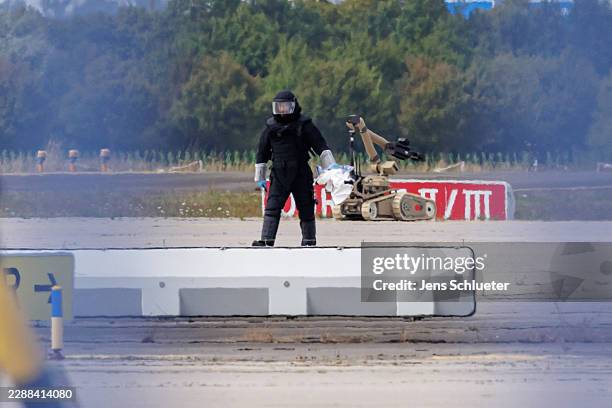 Police investigator works on the tarmac with a robot capable of defusing explosives near a Ukrainian Antonov cargo plane at Leipzig/Halle Airport on...