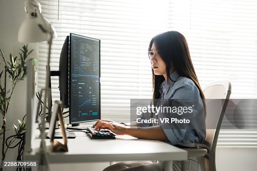 Focused Asian female software developer typing code on keyboard with vertical monitor in modern office, showcasing programming, data analysis, cybersecurity, and women in technology. Focused Asian female software developer typing code on keyboard with vertical monitor in modern office, showcasing programming, data analysis, cybersecurity, and women in technology.