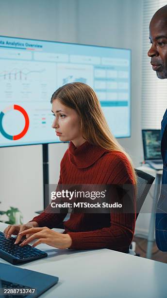 black male manager teaches young white female computer programmer writing code in the corporate office. partnership teamwork planning, artificial intelligence development, innovation concepts. - programmer writing code stock pictures, royalty-free photos & images