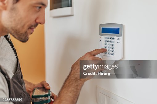 Technician Setting Security System Code on Wall-Mounted Control Panel Technician Setting Security System Code on Wall-Mounted Control Panel