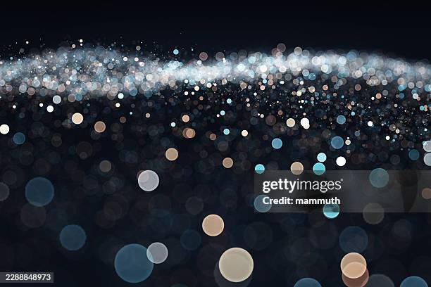 shiny bokeh particles forming a wave, dark digital space, ethereal atmosphere - glitter texture background stock illustrations