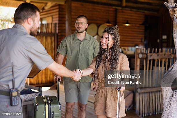 travelers arriving at safari lodge, shaking hands with staff - safari lodge stock pictures, royalty-free photos & images