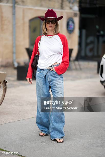 Victoria Thomas is seen wearing a white cotton raglan long sleeve T shirt with red sleeves from Zara; light blue wide leg denim jeans from Agolde...