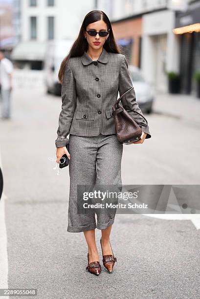 Guest is seen wearing a cropped grey checked tailored jacket; grey wide-leg cropped trousers; brown crocodile-embossed leather pointed-toe mules with...