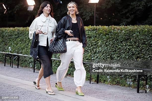 Guest wears an ivory utility jacket with black wide leg shorts, a floral tote and black thong heels, and Polly Newman wears an oversized black...