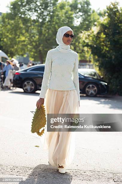 Rawdah Mohamed wears biege sheer balloons pants, light green long sleeve top, matching colour hijab, sunglasses and green spiky bag outside Gestuz...