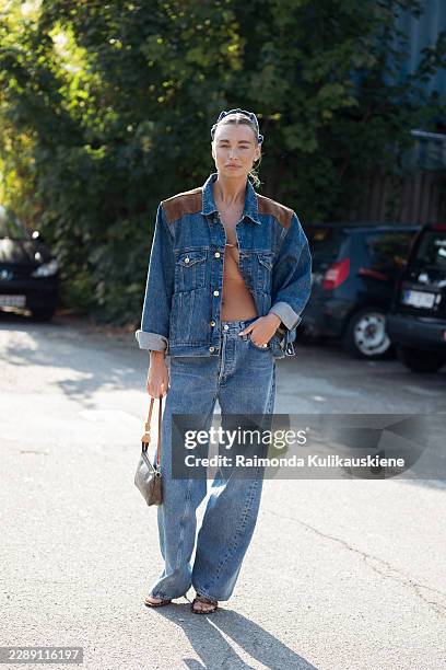 Elena Dizdar wears blue jeans, blue denim jacket with brown details, blue silk hair accessory, brown bag and high heel sandals outside Gestuz show...