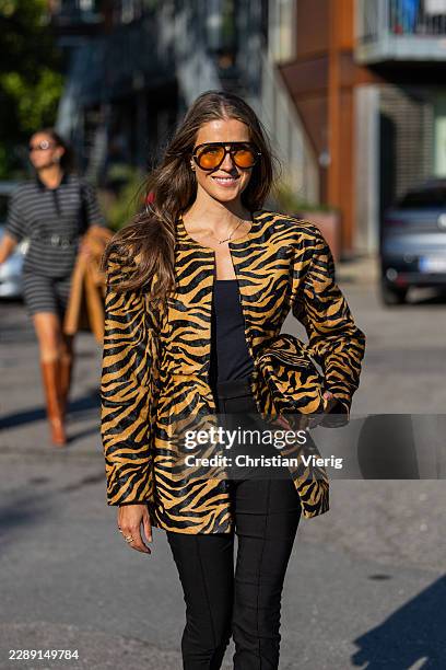 Nina Sandbech wears animal print oversized jacket, bag, cropped black capri pants, sunglasses outside Gestuz during the Copenhagen Fashion Week...