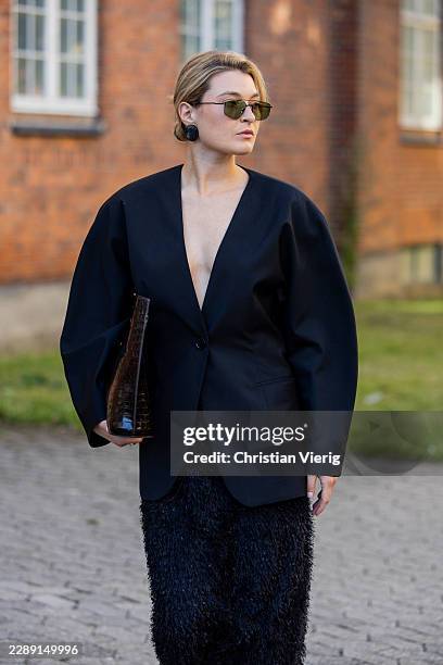 Guest wears black oversized blazer, skirt, bag outside Gestuz during the Copenhagen Fashion Week Spring/Summer 2027 on August 04, 2026 in Copenhagen,...