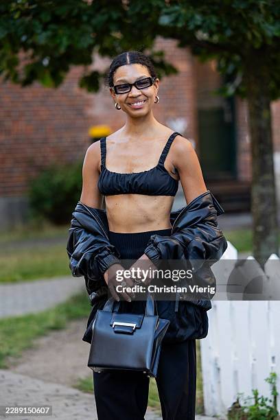 Guest wears black cropped top, pants, jacket, bag outside Gestuz during the Copenhagen Fashion Week Spring/Summer 2027 on August 04, 2026 in...