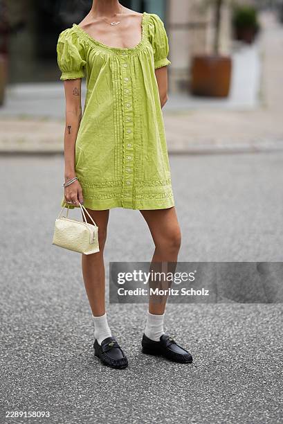 Closer look at Kayla Curtis Evans' lime green cotton mini dress by Damson Madder featuring gathered puff sleeves, front button detailing, and pleated...