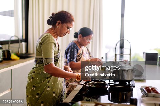 Indian mother and daughter preparing traditional meal Indian mother and daughter preparing traditional meal