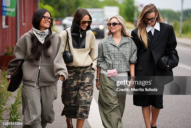Saar Goedegebuur is seen wearing an oversized taupe zip-up hoodie; a printed neck scarf; oversized sunglasses; carrying a Bottega Veneta Intrecciato...