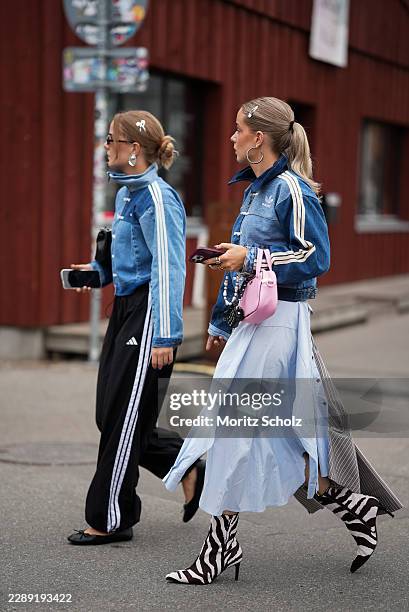 Guest is seen wearing a blue denim track jacket with white stripe detailing from adidas; black track trousers with white side stripes from adidas;...