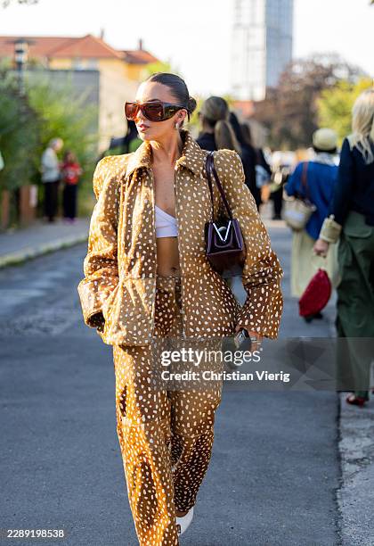 Hetty Appleton-Miles wears oversized brown dots print blazer, pants, brown bag, big sunglasses outside Gestuz during the Copenhagen Fashion Week...
