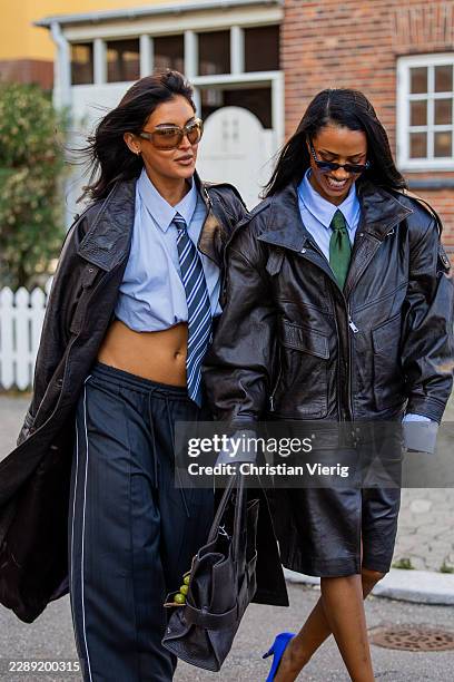 Guest wears black leather coat, cropped blue blouse, tie, navy pants & a guest wears black leather jacket, green tie, leather skirt with slit, blue...