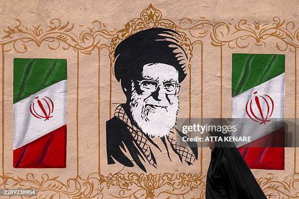 Woman walks past a mural depicting Iran's late supreme leader Ali Khamenei at Valiasr Square in central Tehran on August 8, 2026. Hopes for an...