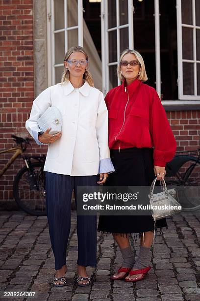 Hollie Mercedes Peters wears blue pants, white jacket and a white bag and eye glasses and Polly Newman wears black skirt, red jacket, silver bag,...