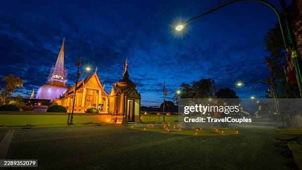 wide angle view of wat phra mahathat woramahawihan at blue hour in nakhon si thammarat, southern thailand. illuminated main stupa, ordination hall, and traditional thai temple architecture stand under a deep blue evening sky. unesco world heritage site. - nakhon si thammarat stock pictures, royalty-free photos & images