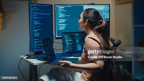 gen z asian female computer programmer types coding on a laptop while working late at night in home office. professional software development, digital transformation, artificial intelligence concept. - application programming interface stock pictures, royalty-free photos & images
