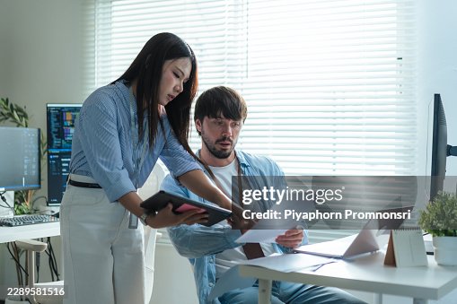 Female programmer assistant male software developer analysis data at coworking workstation office. software development, supporting project management. Female programmer assistant male software developer analysis data at coworking workstation office. software development, supporting project management.