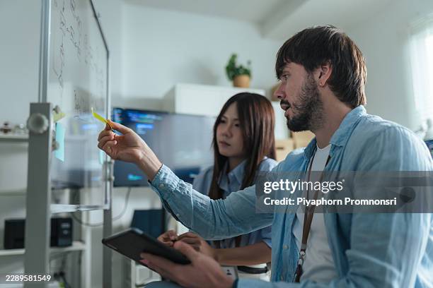 team developer planning project workflow on transparent board together in modern office. brainstorming - api developer stock pictures, royalty-free photos & images