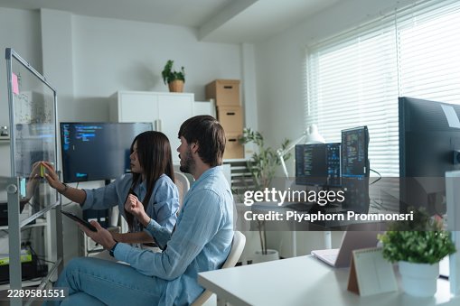 Team developer brainstorming plan coding workflow on transparent board together in modern office. software development, project management. Team developer brainstorming plan coding workflow on transparent board together in modern office. software development, project management.
