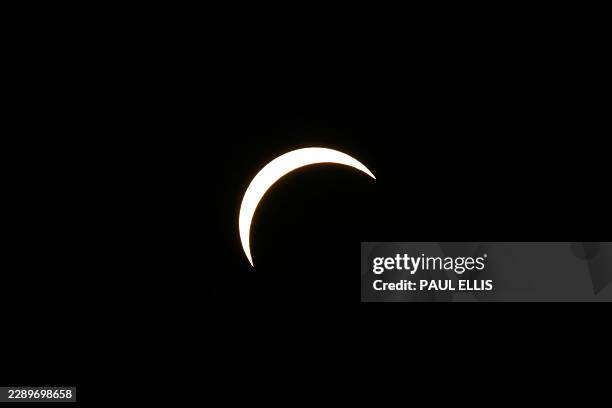 The Moon partially covers the Sun during the solar eclipse as seen from the sidelines of the European Athletics Championships at Alexander Stadium in...