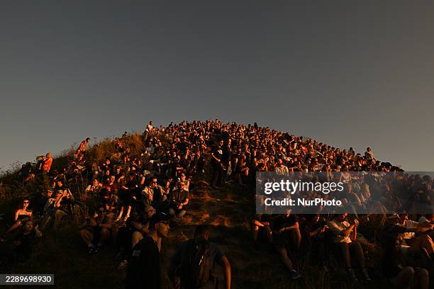 Hundreds of residents and tourists pack the steep, grassy slopes of the historic Krakus Mound during the late afternoon to watch a solar eclipse on...