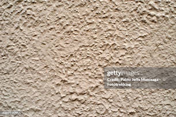 stucco wall texture creating abstract background pattern - bumpy stock pictures, royalty-free photos & images
